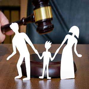 Paper family figures with a gavel overhead.