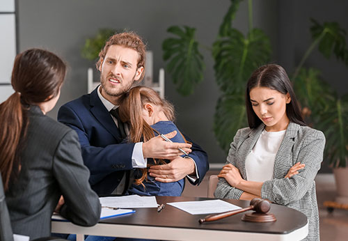 Distressed father comforting his daughter while meeting with Houston family law attorneys