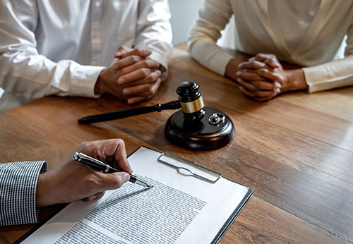 Lawyer advising a couple on divorce papers with a gavel on the table at a Houston firm